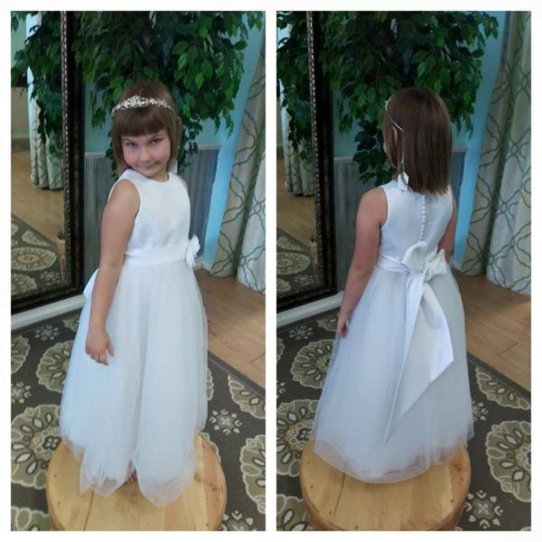 This adorable flower girl dress features a button back and bow in back.